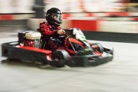 Cart (kart) blurred by high speed, a boy having fun - driving fast, racing, speeding. 