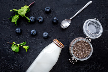 Light dessert with chia seeds, yogurt, blueberry and mint. Black background top view