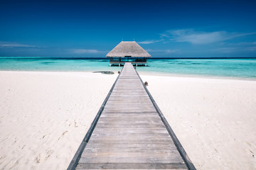 Wooden jetty leading to a terrace on water. Maldives