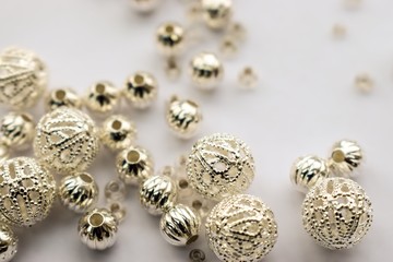 selection of scattered silver beads on white background
