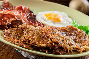 Hash browns. Potato pancakes with crispy fried bacon and fried egg