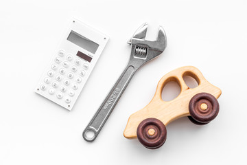 Price of car repair. Wrench near car toys and calculator on white background top view