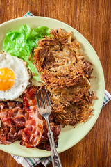 Hash browns. Potato pancakes with crispy fried bacon and fried e