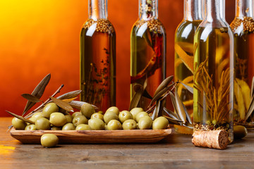Green olives and bottles of olive oil .