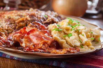 Hash browns. Potato pancakes with crispy fried bacon and scrambled eggs