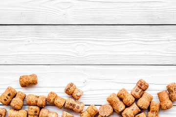 Heap of wine bottle corks on white wooden background top view copyspace