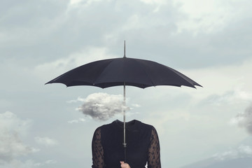 small cloud that repairs from the rain under the umbrella of a headless woman