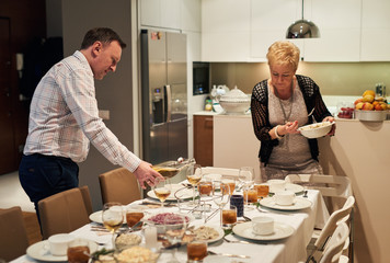 Family setting the dining table together for christmas dinner