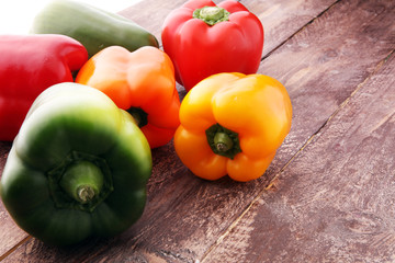 Red, green and yellow sweet bell peppers on table.