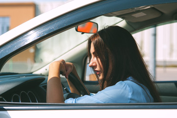 Naklejka premium Beautiful young woman in the silver car