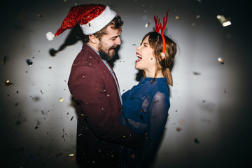 New Year's Party. Girl and boy posing in front of white wall 
 