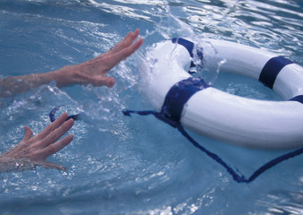 woman's hands reaching for life preserver in blue turbulent water
