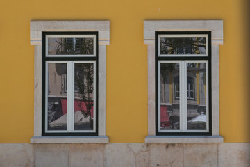Fototapeta na wymiar Two windows and a yellow facade