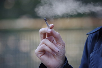 main de femme tenant une cigarette roulée