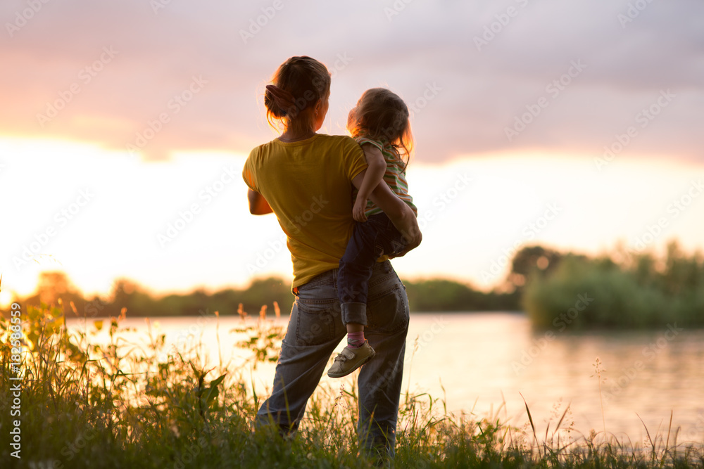 Wall mural Mom and daughter at sunset