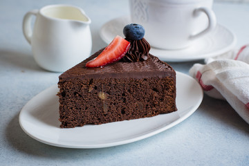 Delicious Piece of chocolate cake with cup of coffee and milk on blue stone concrete table background. Breakfast food concept.