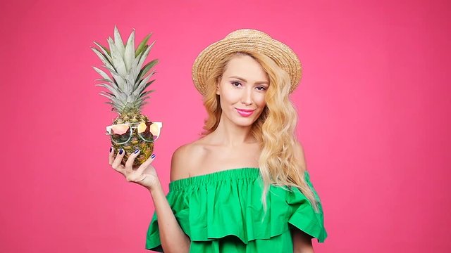 Portrait woman and pineapple with sunglasses over pink background