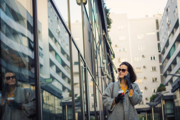 Beautiful woman walking in the city and talking on the phone.