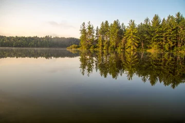 Fototapeten Nördlicher Michigan Wilderness Lake. Wilderness Lake mit Waldreflexionen im Wasser und Kopierraum im Vordergrund in Mio, Michigan. © ehrlif