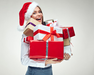 portrait of businesswoman wearing christmas santa hat holding big many of gift boxes.