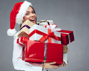 Happy business woman Santa girl holding heap of christmas gift.