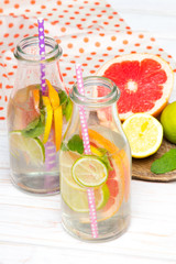 Infused flavored water with fresh fruits on white wooden background.Refreshing summer homemade  detox water