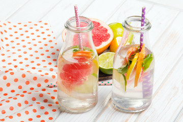 Infused flavored water with fresh fruits on white wooden background.Refreshing summer homemade  detox water