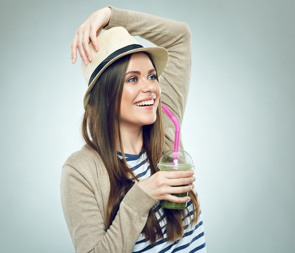  Smiling woman holding glass with green smoothie.