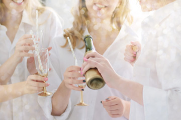 Hand pouring glasses with christmas champagne during the party.