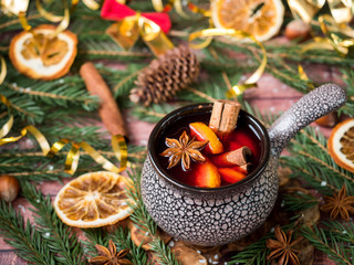 Christmas mulled wine with cinnamon, orange and star anise in a ceramic bowl with winter decorations © Elenglush