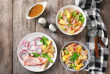 Composition with delicious potato salad and mustard sauce on table