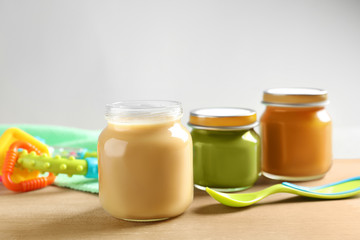 Jars with healthy baby food on wooden table