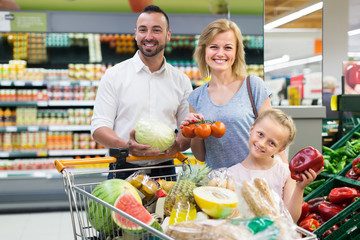 Parents with daughter choosing vegetables