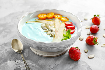 Dish with yummy spirulina smoothie on table. Healthy vegan food concept