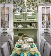 A small living room in the style of Provence in a calm gray-green color scheme. On the table,...