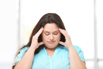 Overweight young woman posing at home