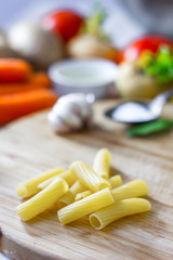 Rigatoni pasta over the wooden kitchen board