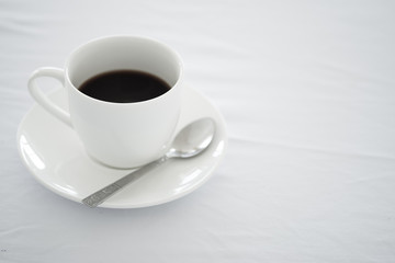 Cup of black coffee placed on white table