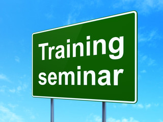 Education concept: Training Seminar on green road highway sign, clear blue sky background, 3D rendering