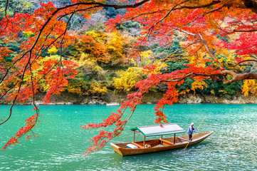 Bootsmann stochert das Boot am Fluss. Arashiyama in der Herbstsaison entlang des Flusses in Kyoto, Japan.