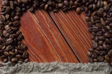 Spilled coffee beans frame over old wooden table