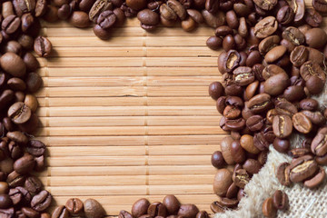 Spilled coffee beans frame over old mat
