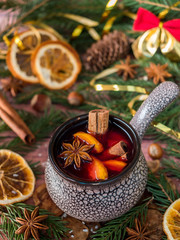 Christmas mulled wine with cinnamon, orange and star anise in a ceramic bowl with winter decorations