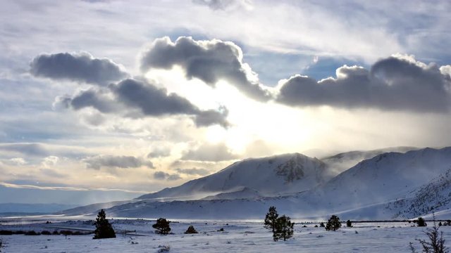 Time Lapse of the clouds moving accross a snow overed landscape.