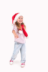 the girl in Santa Claus's cap stands and smiles.