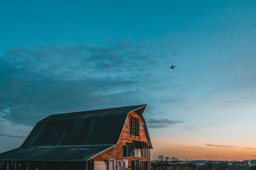 Beautiful Red Barn With Plane Flying Over