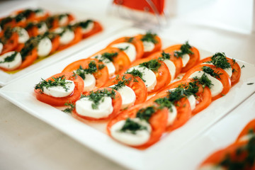 Appetizer canape with cherry tomato, cheese and dill.