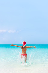 Christmas sun vacation Santa Claus hat woman happy on cruise travel holidays beach in Caribbean holiday getaway destination for honeymoon.