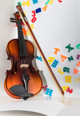  A Small Children's Violin and Bow on a Child's Study Desk