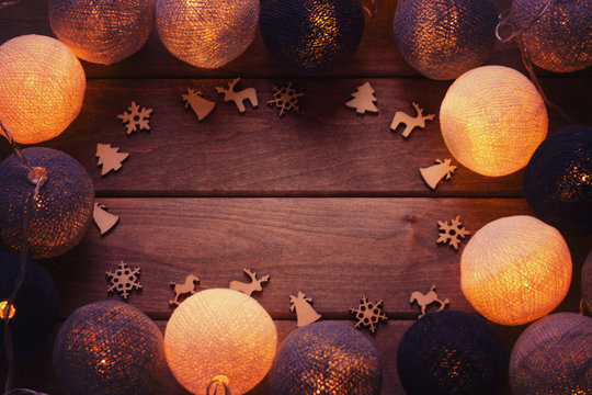 Beautiful lanterns garlands like balls and christmas decoration over wooden background 